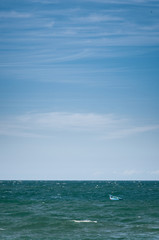 Obraz premium An empty blue boat floating on the ocean.