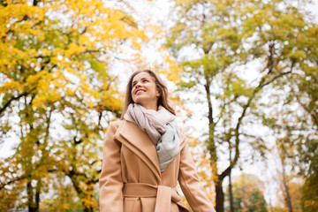beautiful happy young woman walking in autumn park