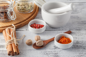 Mortar and pestle with pepper and spices on wooden table