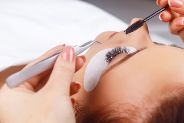 Eyelash Extension Procedure. Woman Eye with Long Eyelashes. Eyelashes with rhinestone. Lashes, close up, macro, selective focus.