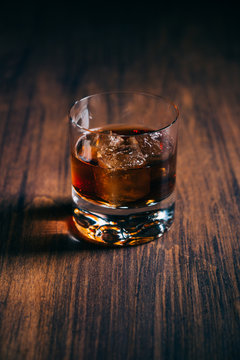 Glass of whiskey on a wooden table