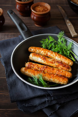 Pan of fried sausages with coriander