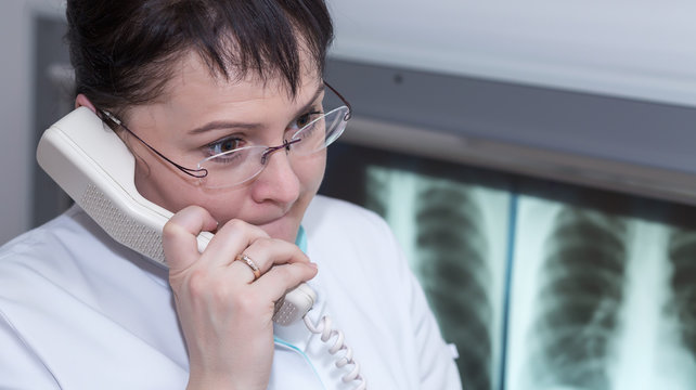 Brunette female x-ray doctor talking on the phome