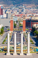 Fototapeta na wymiar Square of Spain in Barcelona with two Venetian towers in red brick and columns in the foreground, Plaza de Espana. Spain.