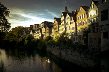 Naklejka premium Ansicht der Tübinger Altstadt Neckarfront mit Neckar in bedrohlich wirkendem Abendlicht, teils bewölkter Himmel