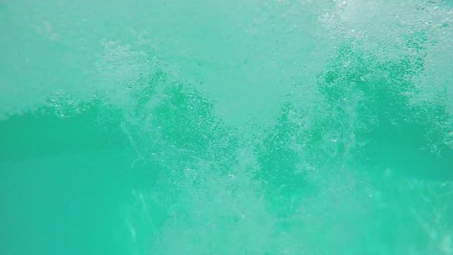 Man dives into pool, underwater shot, slow motion.