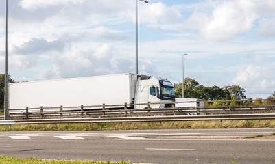 Fototapeta na wymiar White lorry in motion on the motorway