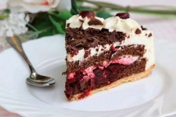 Black Forest cake on the white plate with flowers
