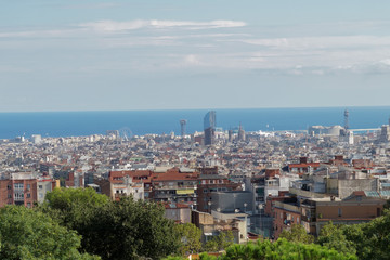 Fototapeta na wymiar Barcelona, Spain panoramic view from Nature Square at Park Guell Monumental Zone. The public park designed by Antoni Gaudi offers a wide view of Barcelona City. 