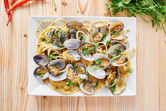 Pasta with steamed clams in white square dish