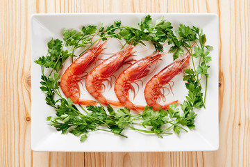 Raw prawns and parsley on white dish