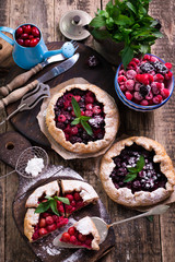 Obraz na płótnie Canvas Blueberry,cherry,raspberry and blackcurrant galette on w wooden background.