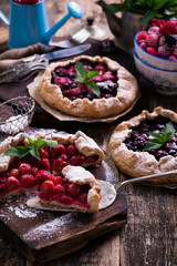 Blueberry,cherry,raspberry and blackcurrant galette on w wooden background.