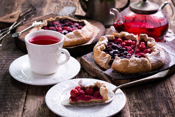 Blueberry,cherry,raspberry and blackcurrant galette on w wooden background.