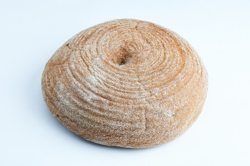 A loaf of round black bread on the isolated white background. Covered in flour fresh homemade bread.
