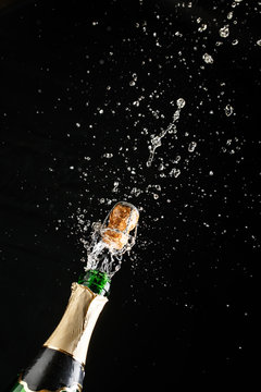 Classic champagne bottle with cork exploding, alcoholic beverage