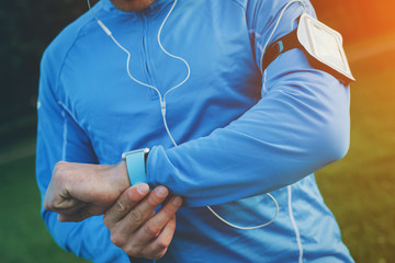 Athlete checking time results at his smart watch on the wrist