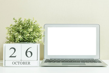 White wooden calendar with black 26 october word with white blank space at center of computer...