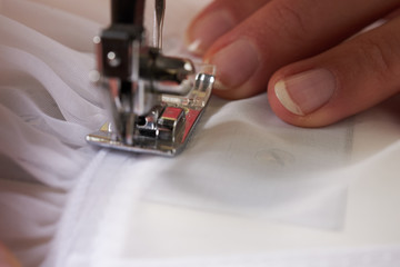 Young woman sewing fabric