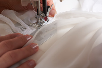 Young woman sewing fabric