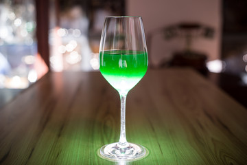 A glass on the table with a green drink