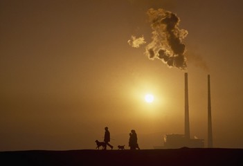 Silhouette Of People Walking Past Power Station; Poolbeg, Co Dublin, Ireland