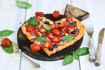 Pizza with pepperoni, tomatoes, mozzarella, on vintage wooden table background. Valentines Day concept