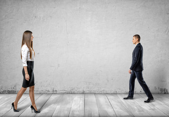 Obraz premium Businesswoman and businessman going opposite to each other.