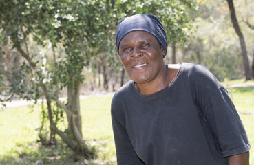 Naklejka na ściany i meble Smiling Older South African Woman Standing in Yard Where she is Gardener
