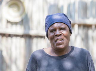 Smiling Older South African Woman Standing in Front of Shed