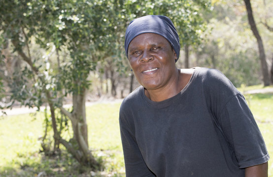 Smiling Older South African Woman Standing in Yard Where she is Gardener