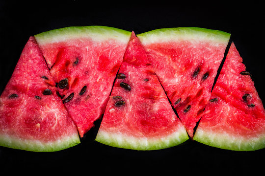 Slices of watermelon on a plate on a wooden background