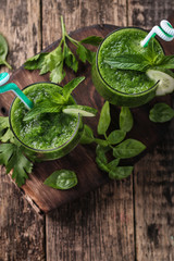 Fresh green smoothie with straws on a wooden table,healthy vegan food