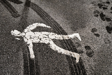Pedestrian road figure covered in tire track marks