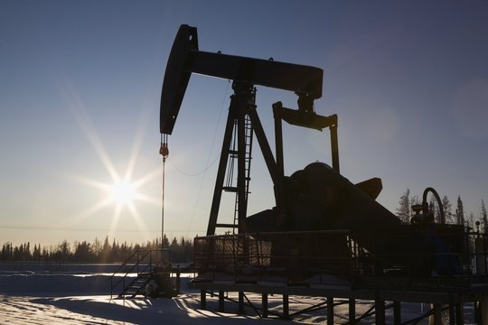 Edson, Alberta, Canada; Silhouette Of A Pump Jack With A Sunburst In Winter
