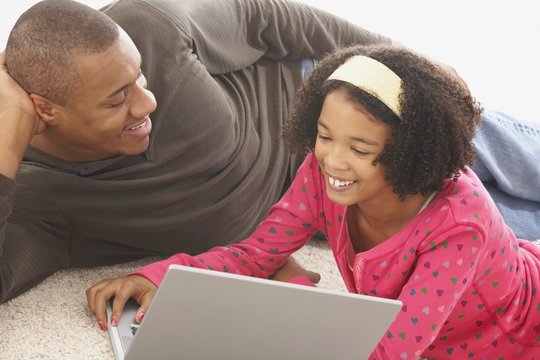 A Father And Teenage Daughter With A Computer