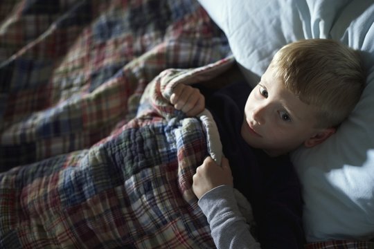 A Boy Laying Awake In Bed