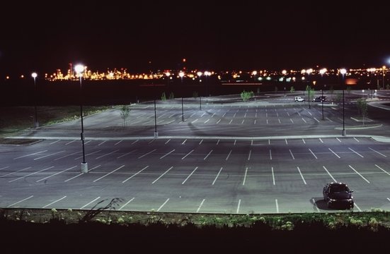 An Almost Empty Parking Lot Illuminated At Night
