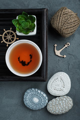 Cup of black tea and crocheted pebbles