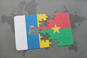 puzzle with the national flag of canary islands and burkina faso on a world map background.