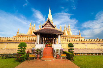 Religious architecture and landmarks. Golden buddhist pagoda of Phra That Luang Temple under sunset sky. Vientiane, Laos travel landscape and destinations