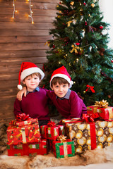 Obraz na płótnie Canvas Children under Christmas tree with gift boxes.