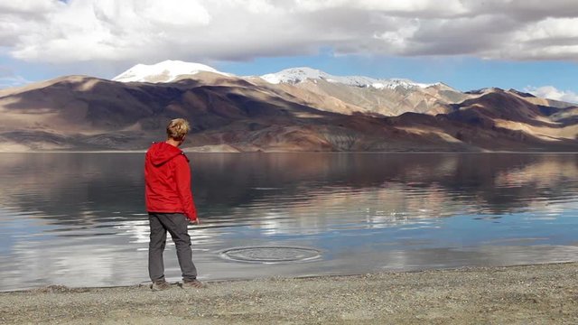 Young teen stone skipping on Tso Moriri lake with the mountain background, Ladakh,India