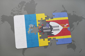 puzzle with the national flag of canary islands and swaziland on a world map background.