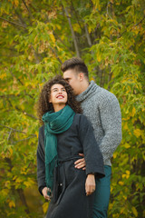 beautiful couple in the autumn forest. Curly girl