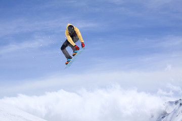 Snowboarder jumping in mountains, extreme sport.