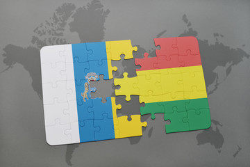 puzzle with the national flag of canary islands and bolivia on a world map background.