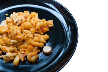 macaroni pasta in tomato sauce on black disc