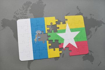 puzzle with the national flag of canary islands and myanmar on a world map background.
