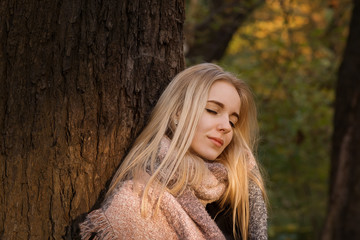 happy blond girl with closed eyes near tree, toned image